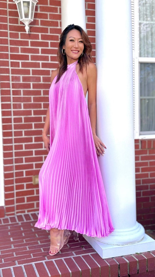 ShopJenny Boutique model is pictured wearing Charlotte Satin Pleated Halter Midi Dress - Lavender made by Strut & Bolt.