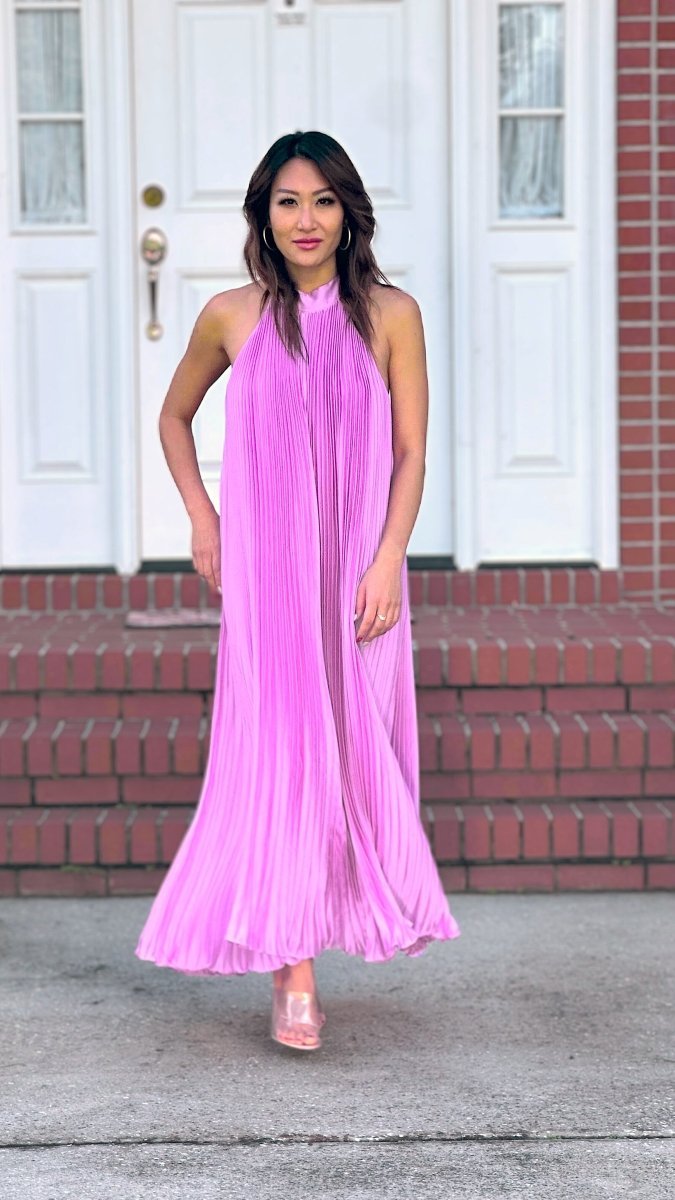 ShopJenny Boutique model is pictured wearing Charlotte Satin Pleated Halter Midi Dress - Lavender made by Strut & Bolt.
