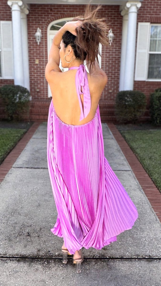 ShopJenny Boutique model is pictured wearing Charlotte Satin Pleated Halter Midi Dress - Fuchsia made by Strut & Bolt.