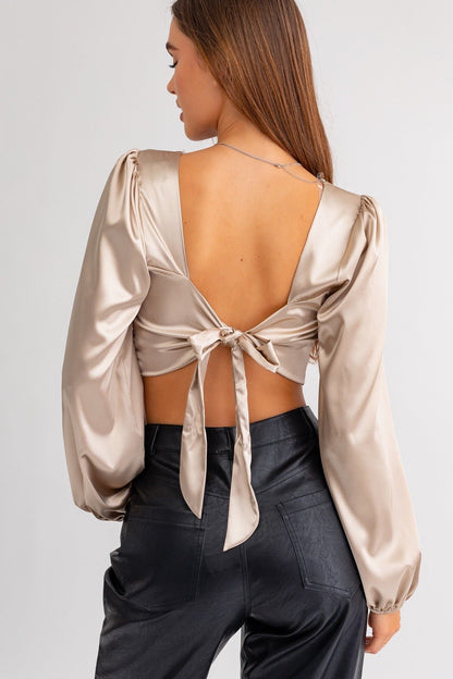 ShopJenny Boutique model is pictured wearing Polly Satin Open Back Tie Top - Champagne made by LE LIS.